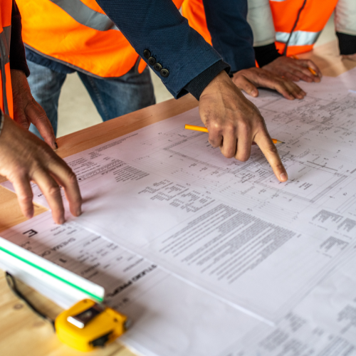 Group of contractors reviewing construction plans before beginning their work for the day.